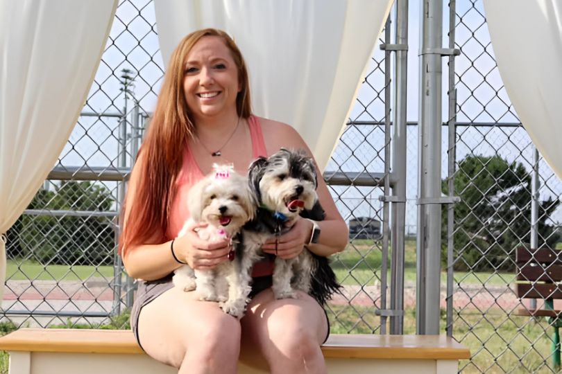 a lady holding two puppies